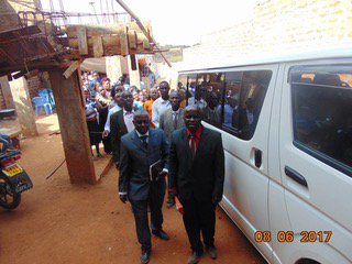 Group of churchgoers standing next to vehicle