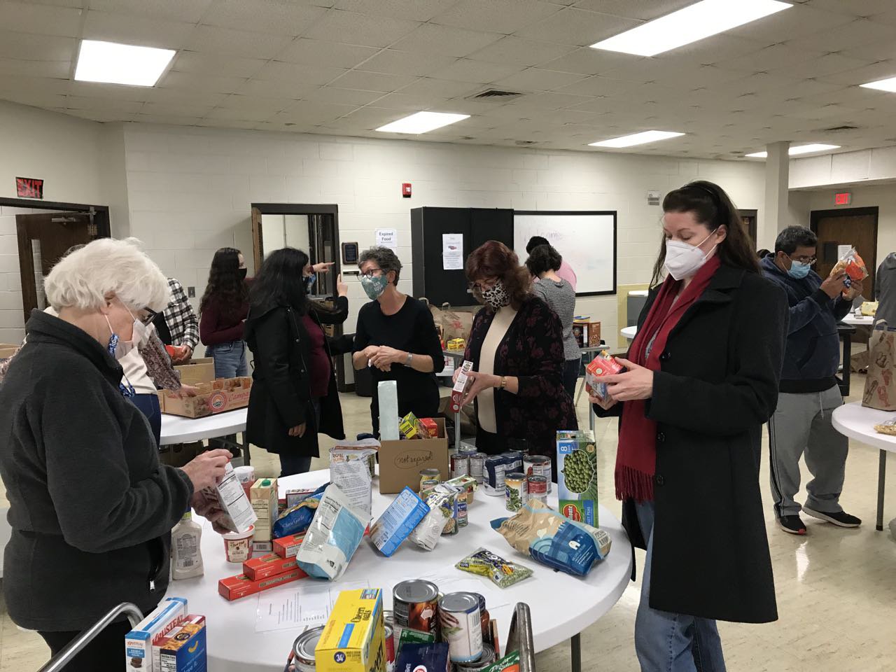 Volunteers sorting food and checking expiration dates.