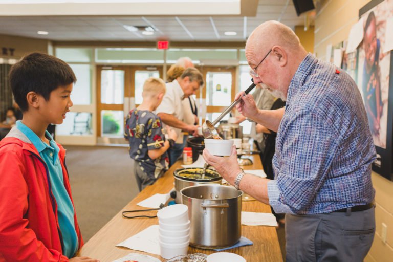 One of our volunteers serving a young visitor lunch.