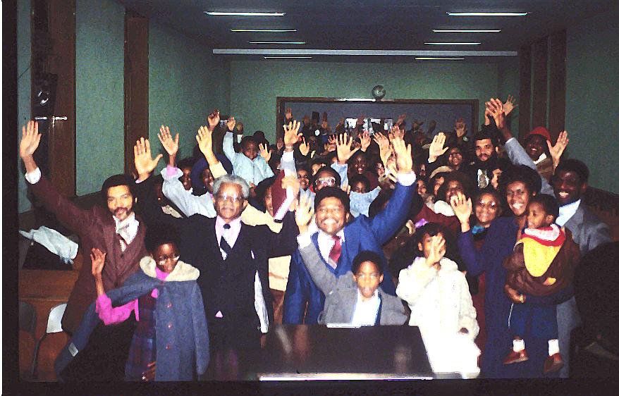 The Pioneers of the New Covenant Church of Philadelphia raise their hands during the very first service.